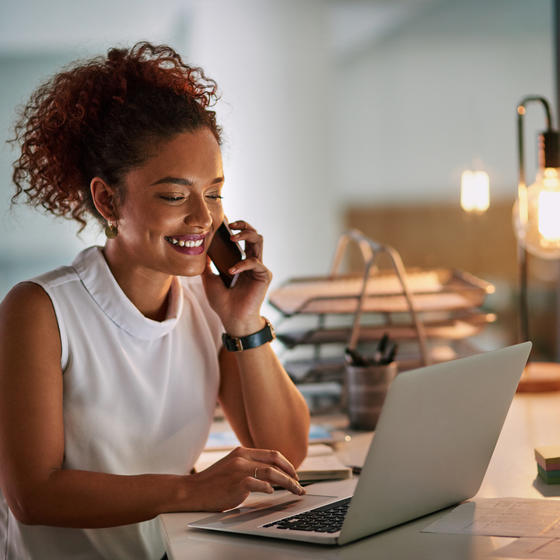 woman working on her phone and laptop