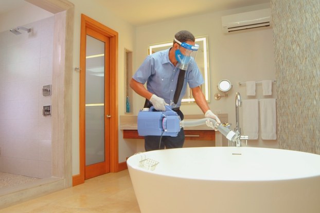 sandals employee cleaning bathtub