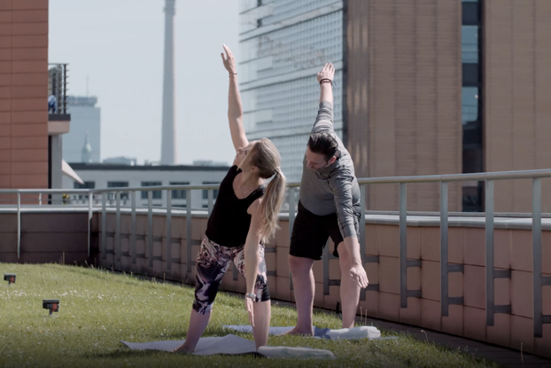 two people doing rooftop yoga at hyatt hotel