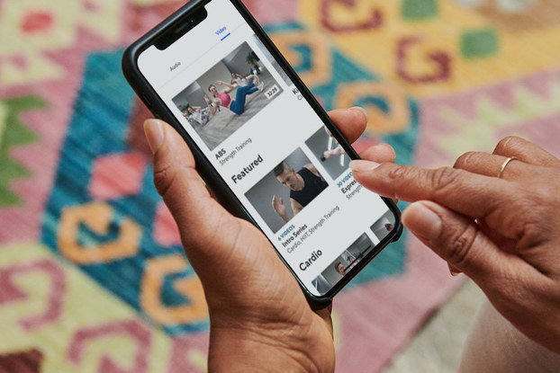 person holding phone browsing classpass workouts