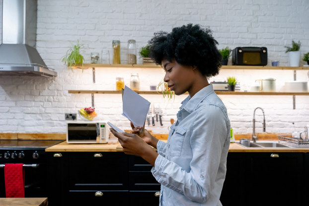 woman in kitchen going through her mail