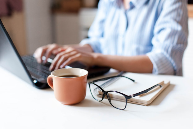 person working remotely at desk with coffee