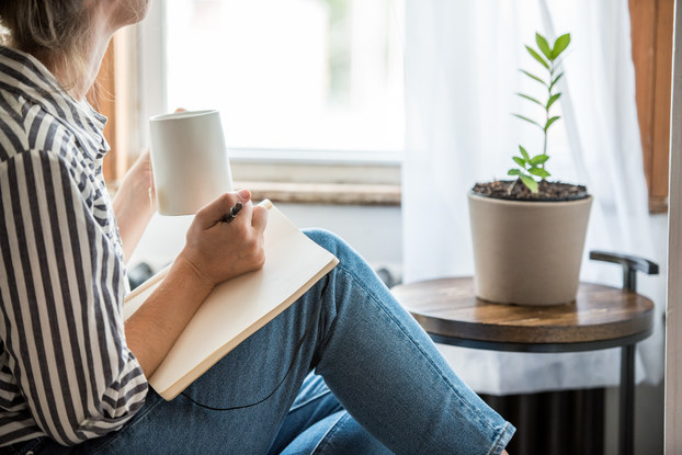 woman sitting and writing with pen and paper