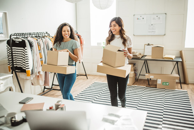 two women at work holding boxes