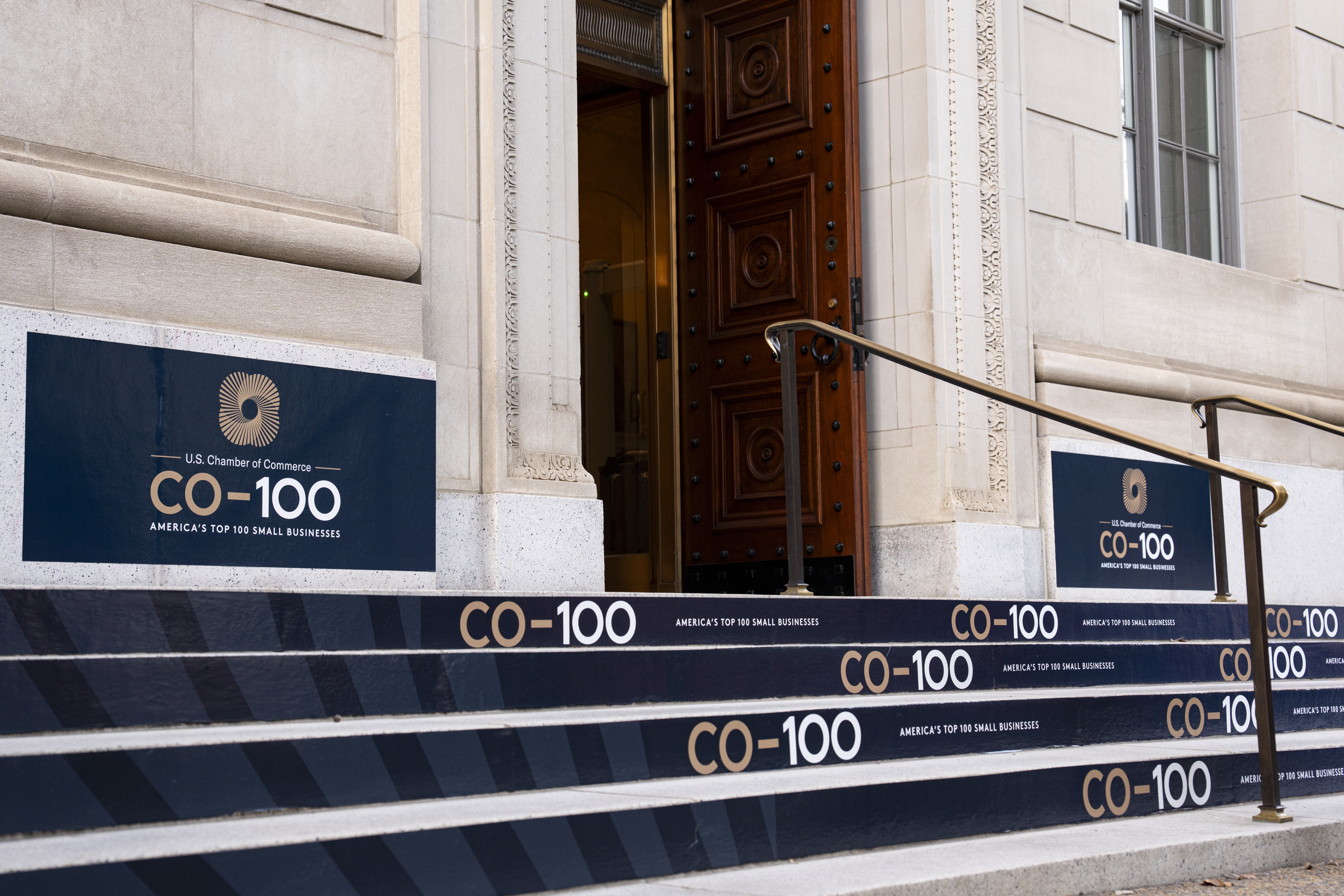 The U.S. Chamber of Commerce's CO-100 branding is prominently displayed and signage outside the Chamber headquarters building.