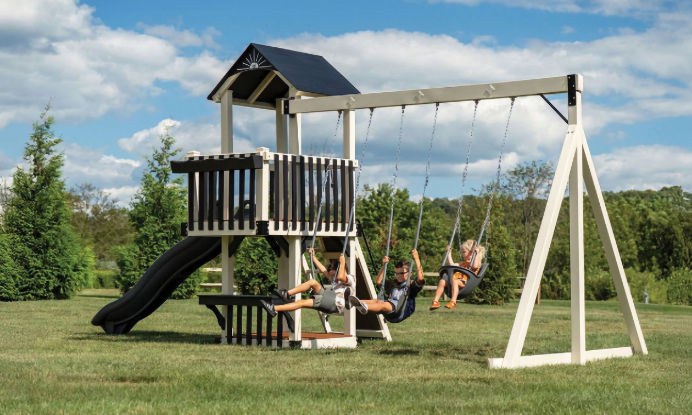 Three small children swing on a King Swings large swing and playset.