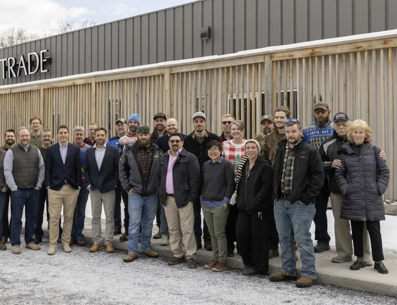 a group of Trade Design Build employees standing in front of the company's building