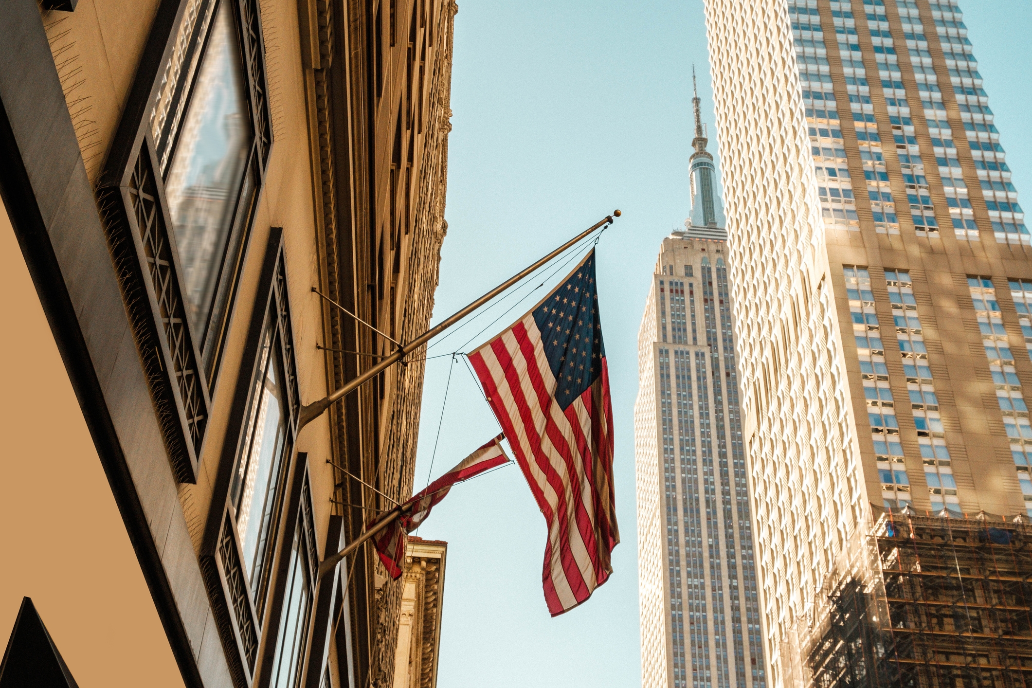 An American flag on a building. View is of the camera looking up from a city street.