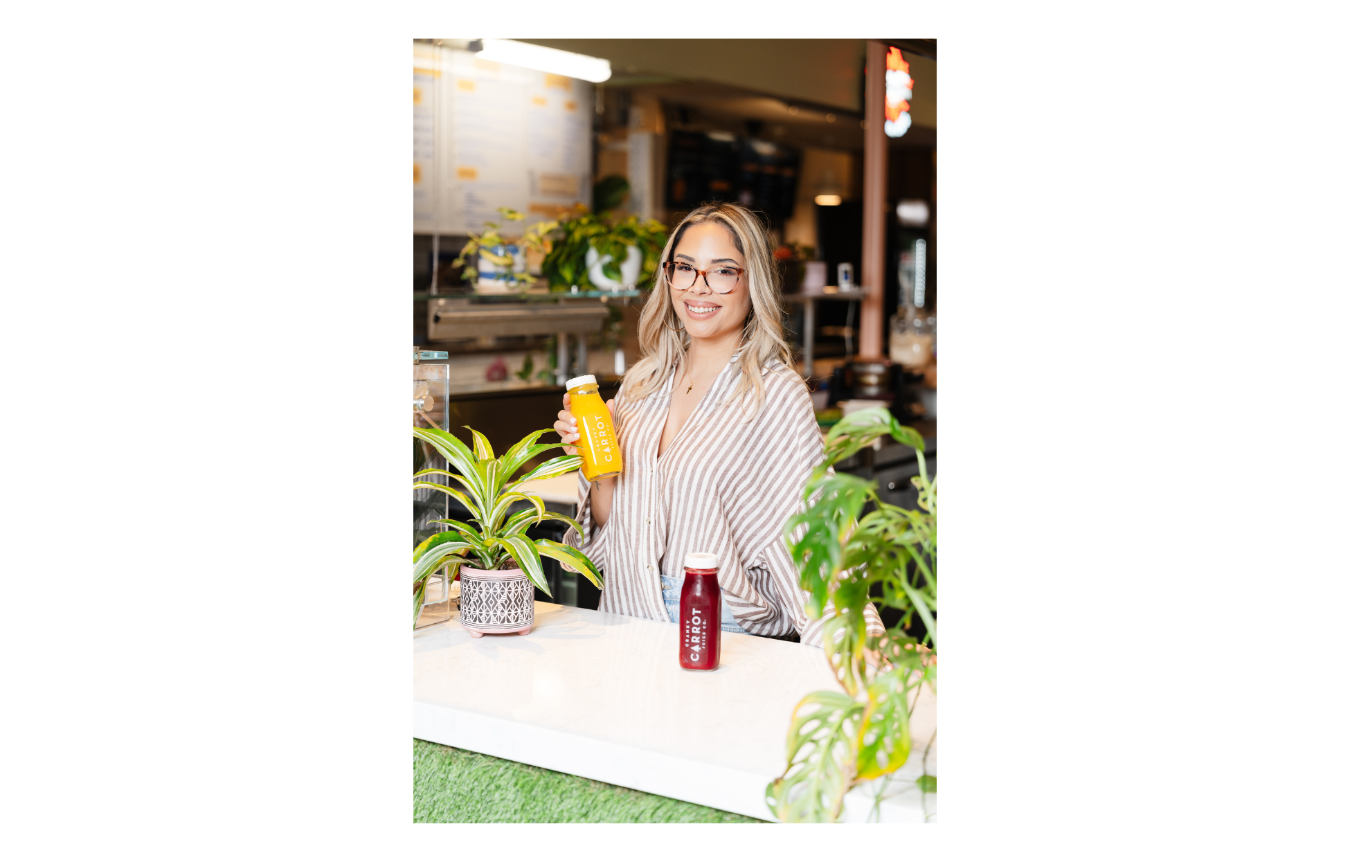 Francesca Costa, Founder of Cranky Carrot Juice Co., holding a bottle of juice inside her business.