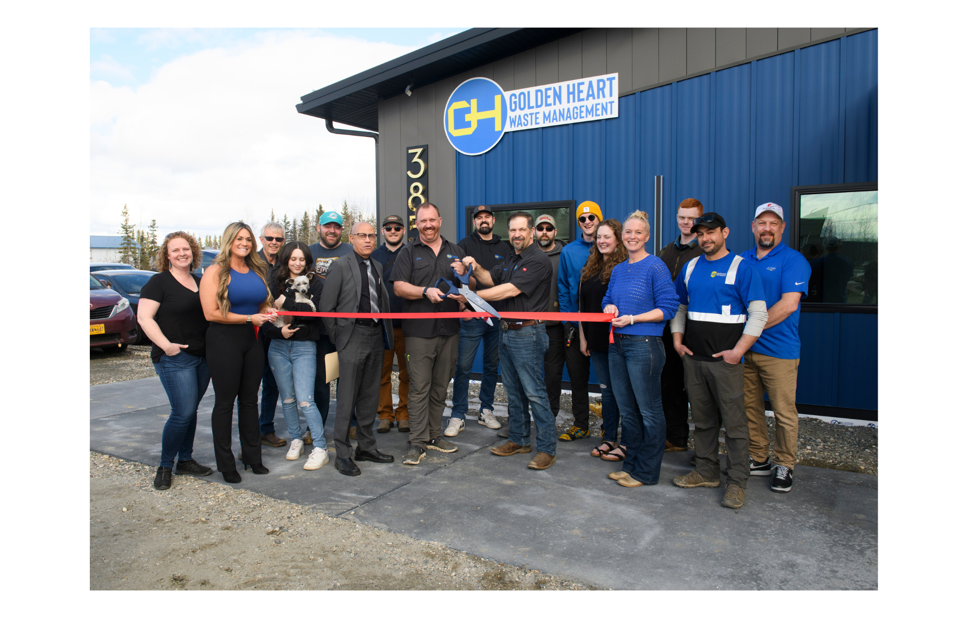 The team behind Golden Heart Waste Management standing outside their headquarters ready to cut the red ribbon.