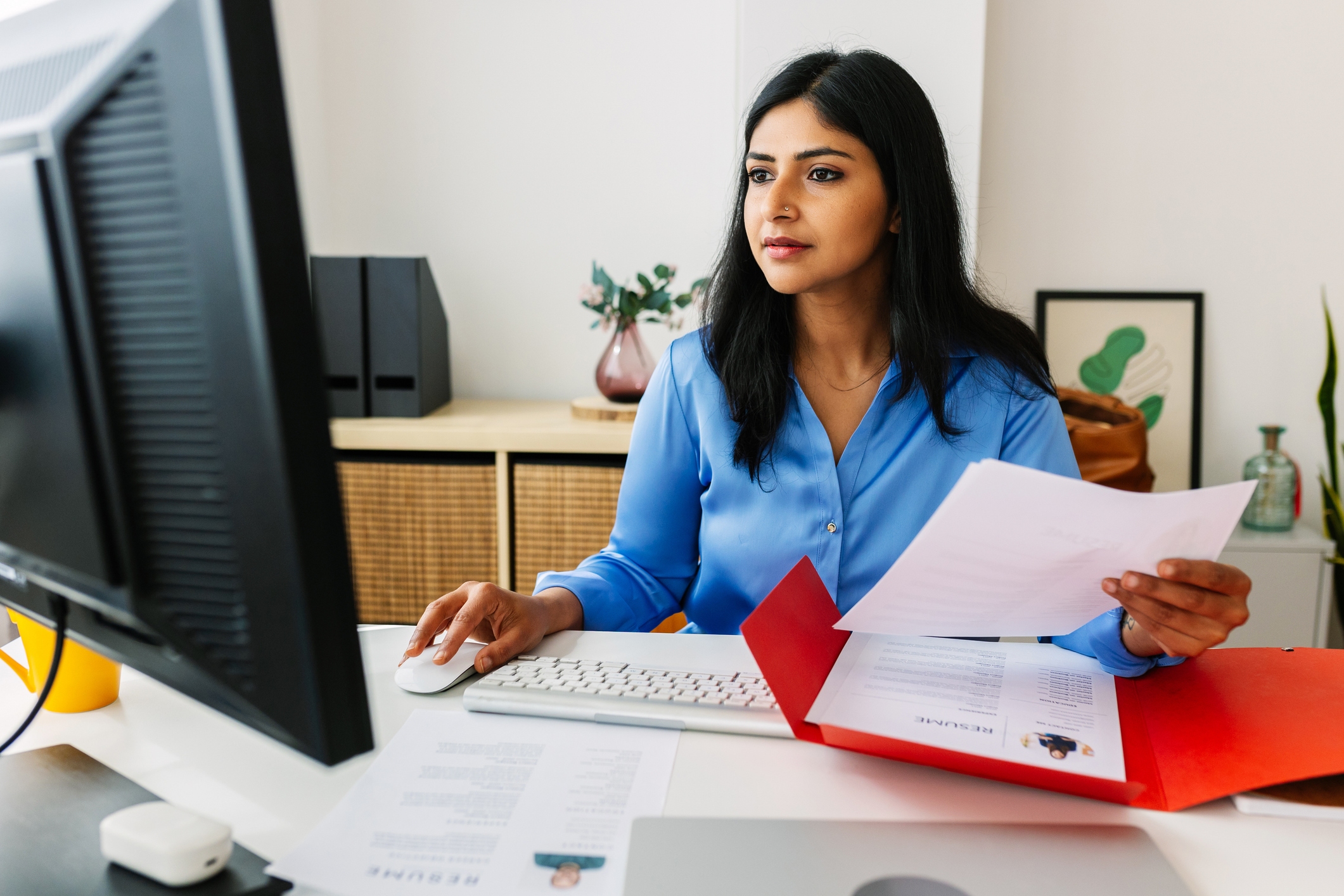 Professional Indian HR manager reading job candidate’s resume in her office while working on laptop. Recruitment human resources employment hiring concept.