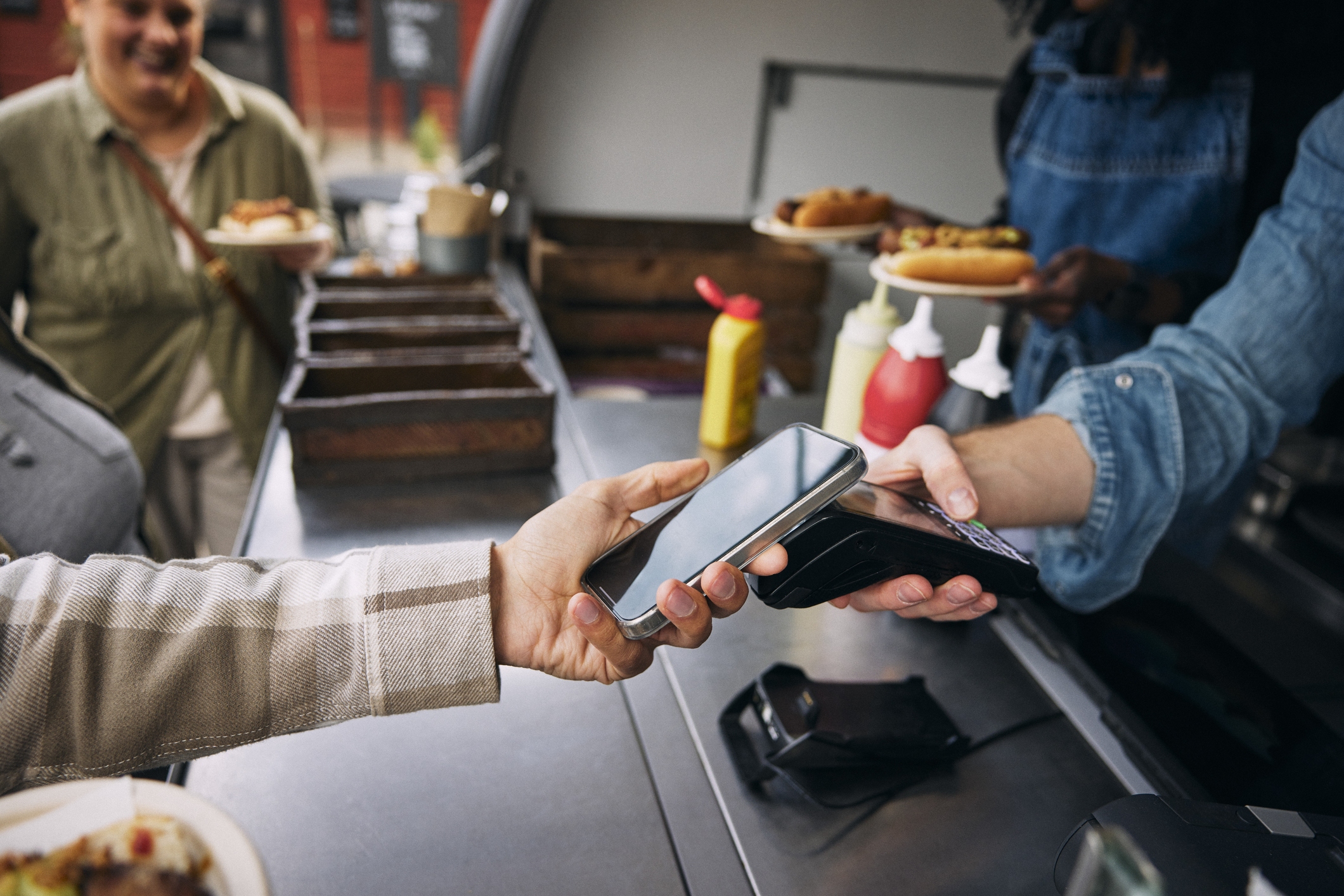 A person paying with a phone at a restaurant.