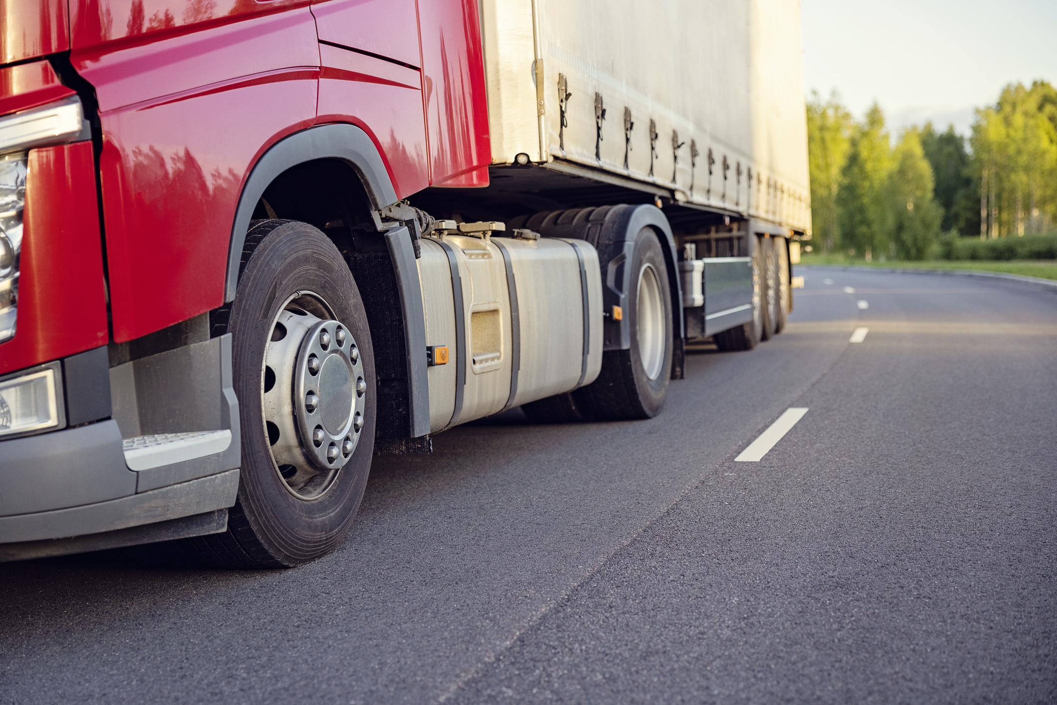 A close up of the bottom half of a truck driving on the road.