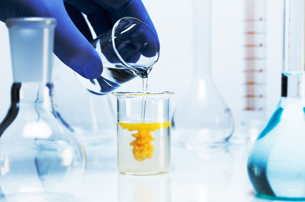 A chemist mixing chemicals in a beaker.