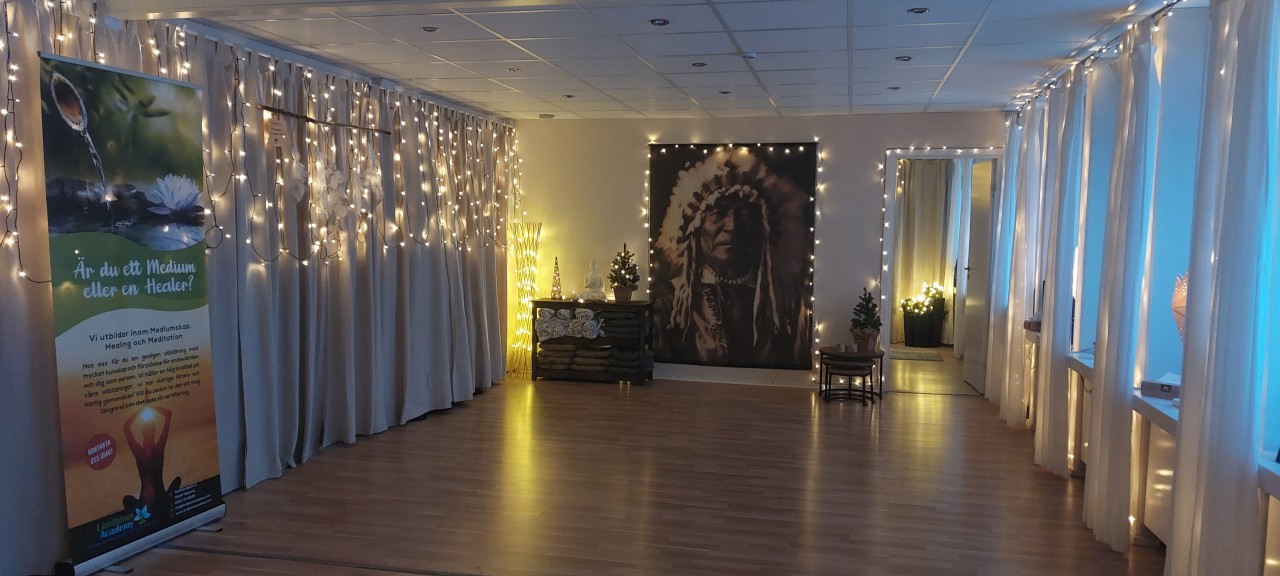 Den stämningsfulla meditationsstudion hos Lindblom Academy i Västerås, dekorerad med ljusslingor, mjuka gardiner och en andlig fondvägg.