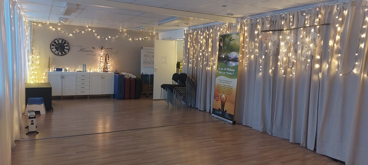 Överblick av kurslokalen i Västerås som visar den öppna ytan, ljussättningen och ordningen inför en gruppmeditation eller healingkurs.