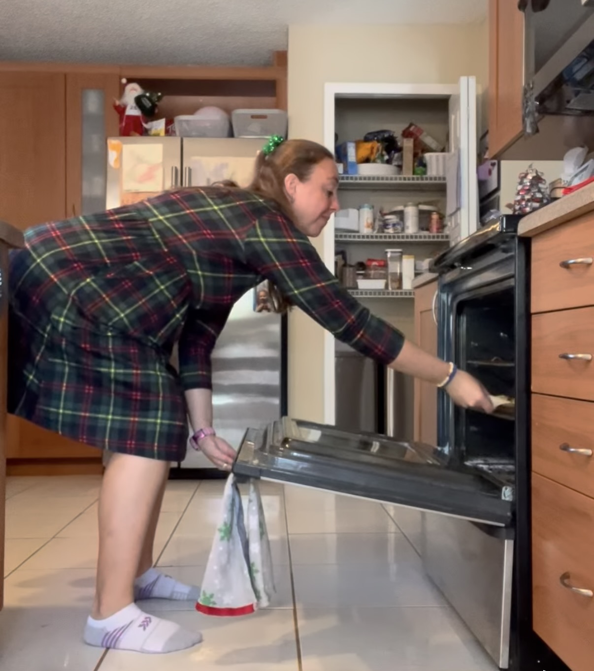 Mom hinged over and putting cookies in an oven