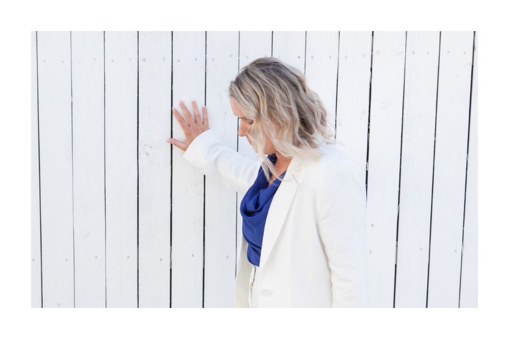 Annie Richardson breathwork and preveral trauma specialist is standing beside a still pool of water, offering rebirthing breathwork and somatic release practices.