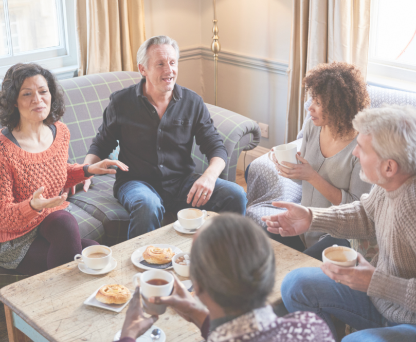 two couples enjoying food and talking in the living room 