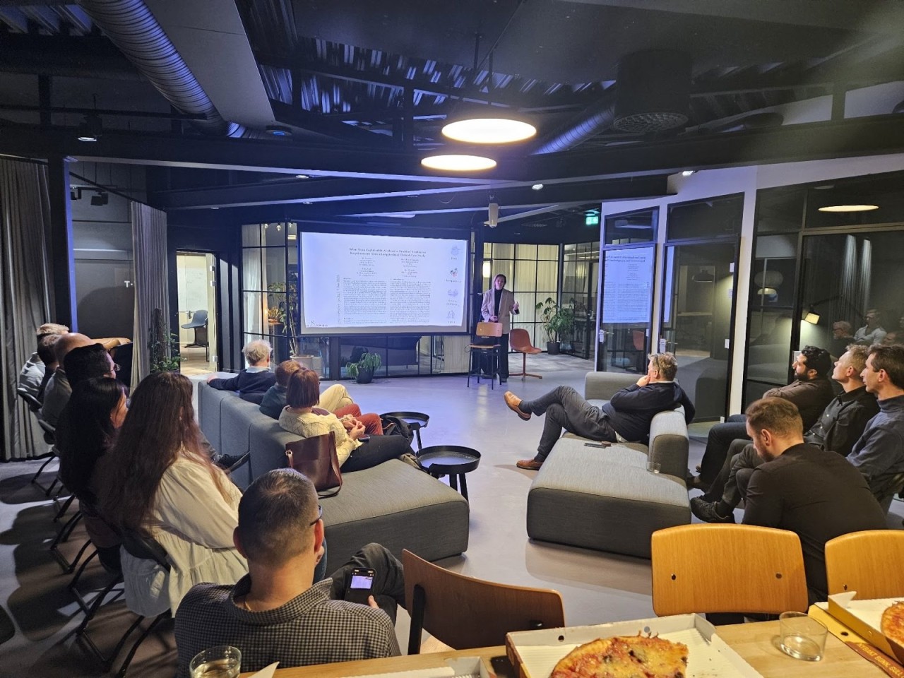 An evening at the AI meetup in Bergen, people on sofas watching a talk