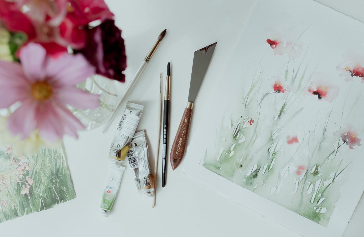 Akvarellmaterial Akvarellpenslar och akvarellpapper med målade rosa blommor