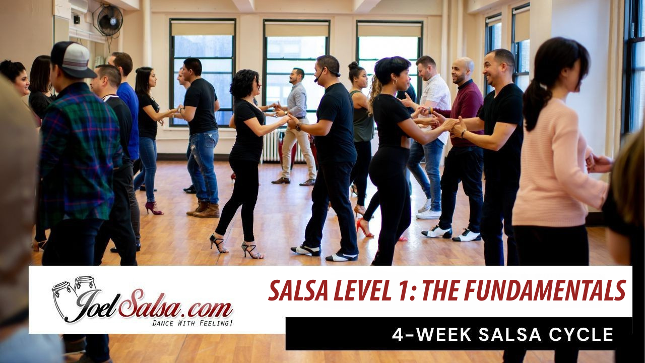 Room full of student Salsa dancing in couples at Joel Salsa