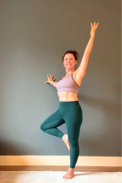 adapating yoga postures hand on wall in tree