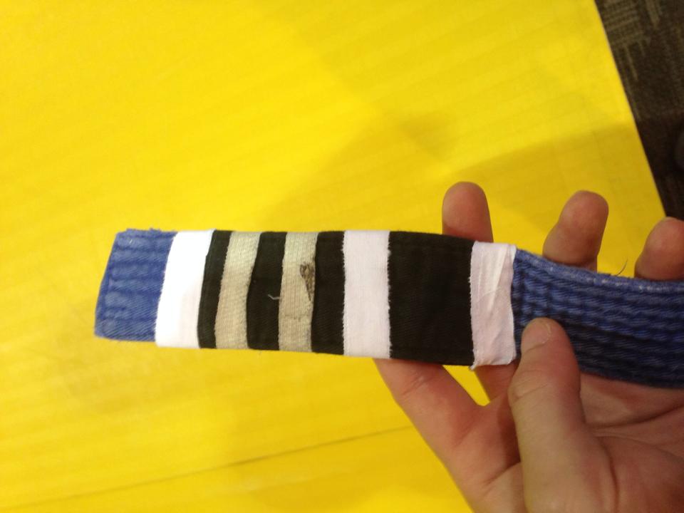 Brazilian Jiu Jitsu blue belt with stripes showing progress through training