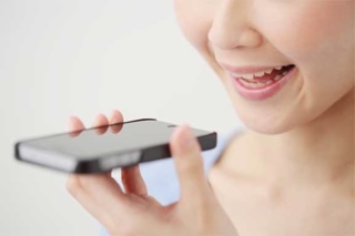 Person speaking into a smartphone microphone while using blurting study technique.