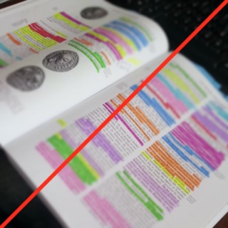 Open textbook filled with multicolored highlighting and a red line crossing through it.