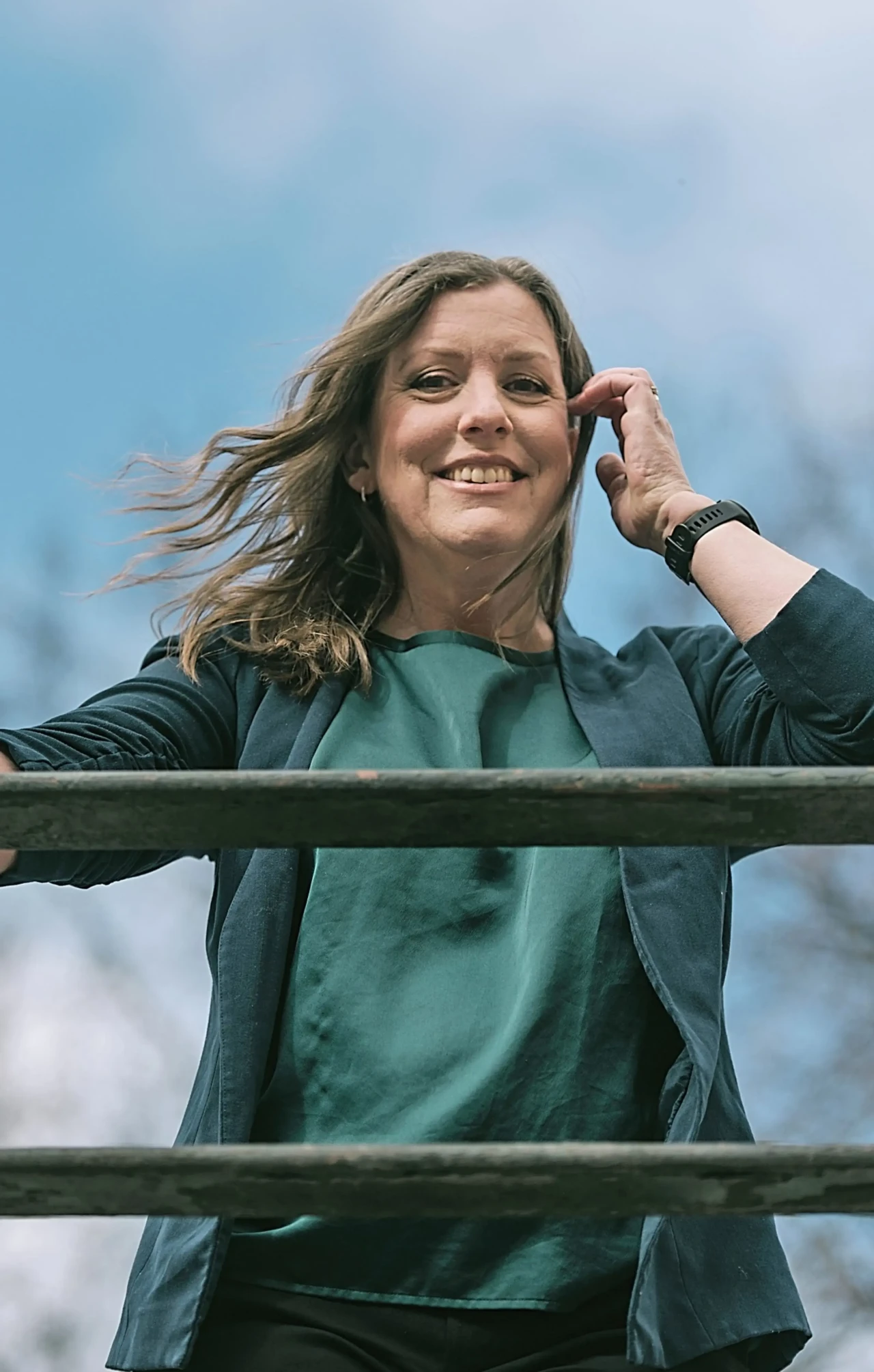 Anneli Olsson, författare och grundare av Storysmedjan Författaren Anneli Olsson med vinden i håret och blå himmel bakom sig