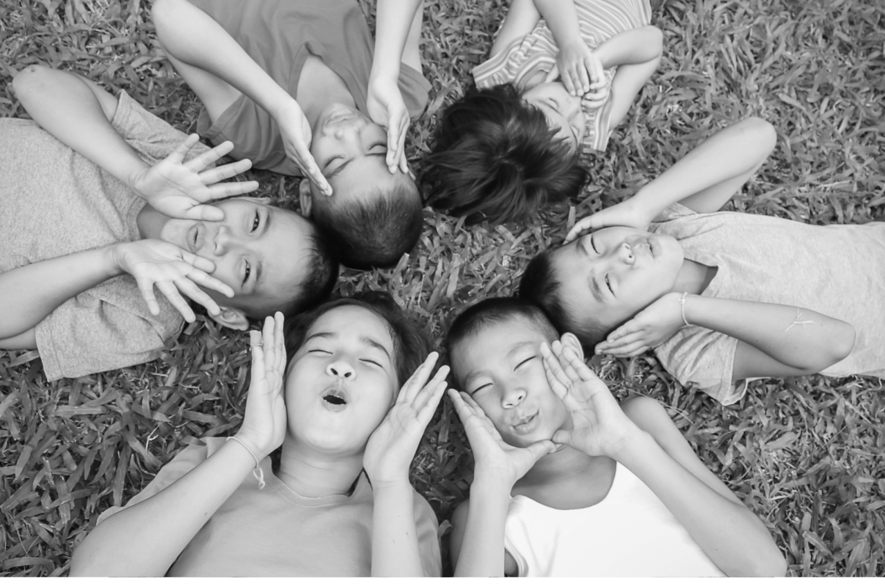 Group of children lying on the ground in a circle