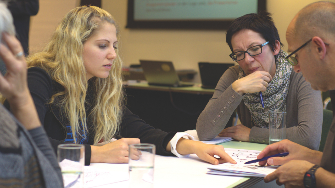 group of people sitting round table learning together