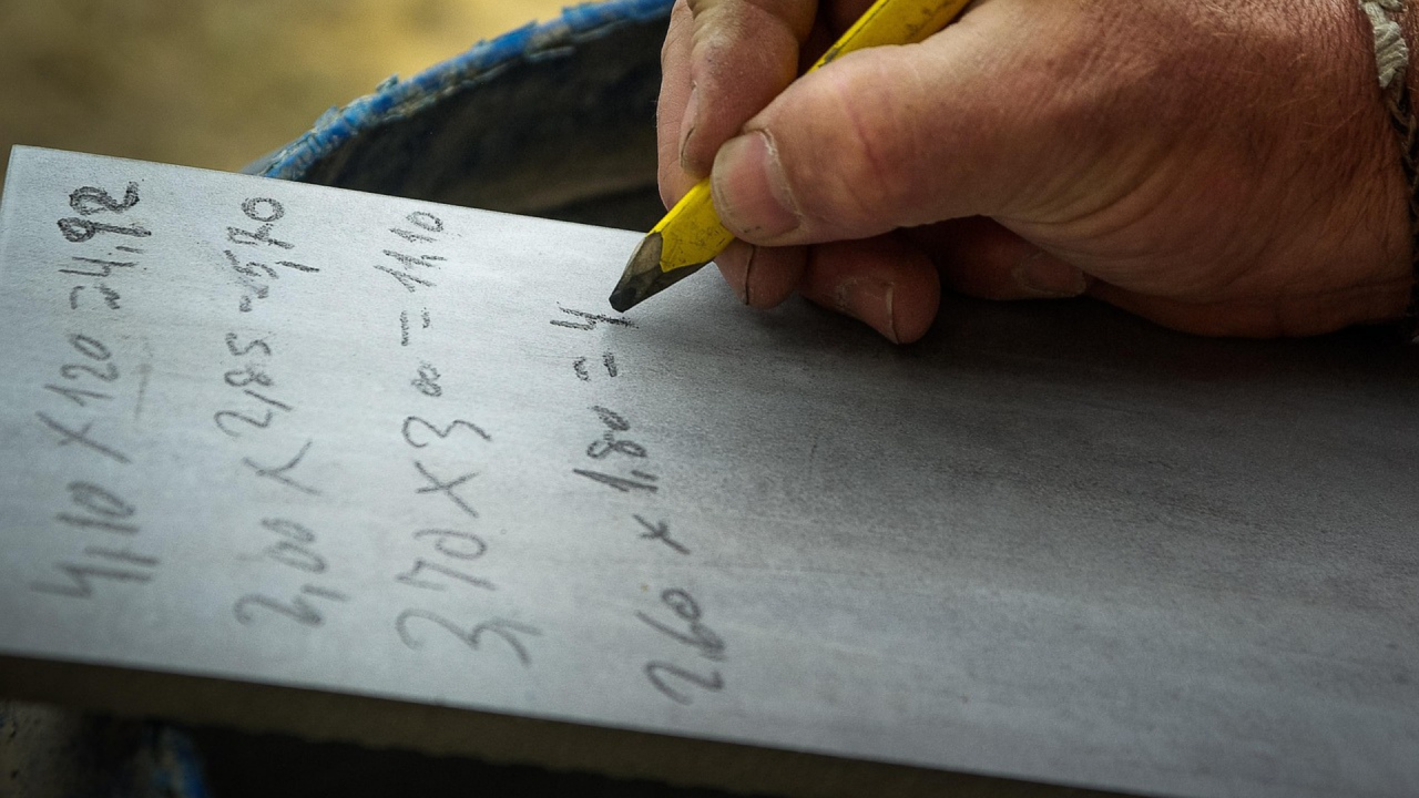 person writing mathematic calculations with pencil and paper