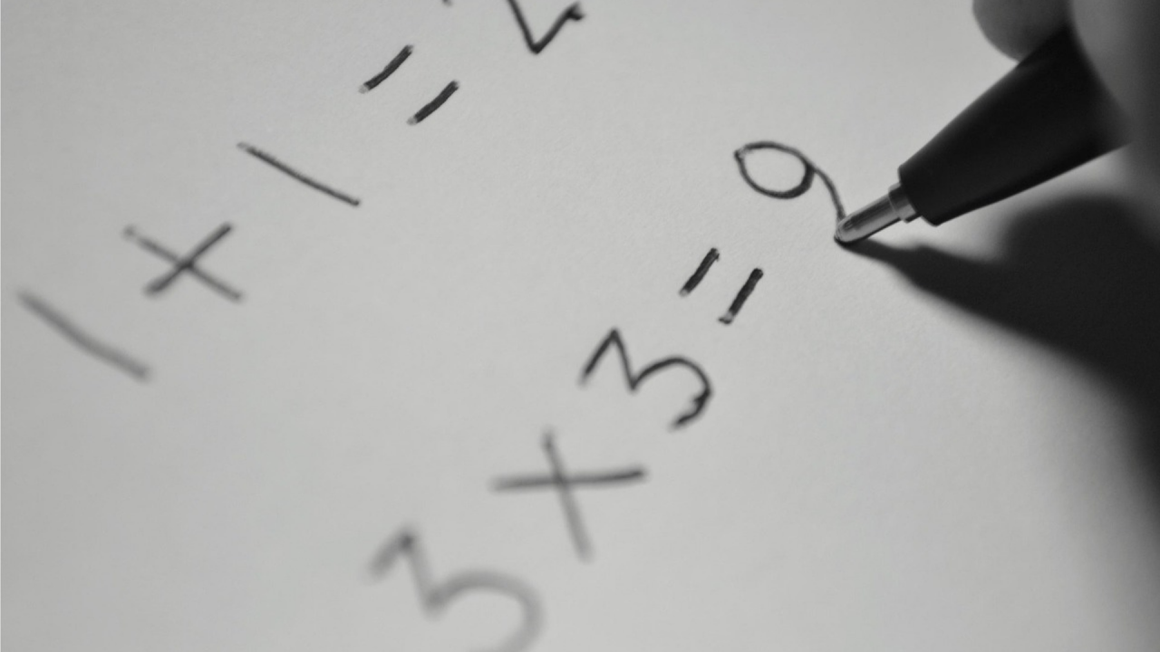 person completing maths calculation with pen on paper