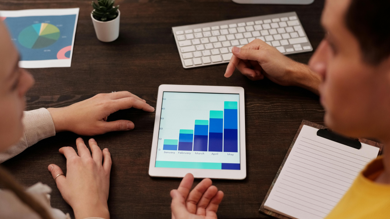 two people looking at a graph on a tablet