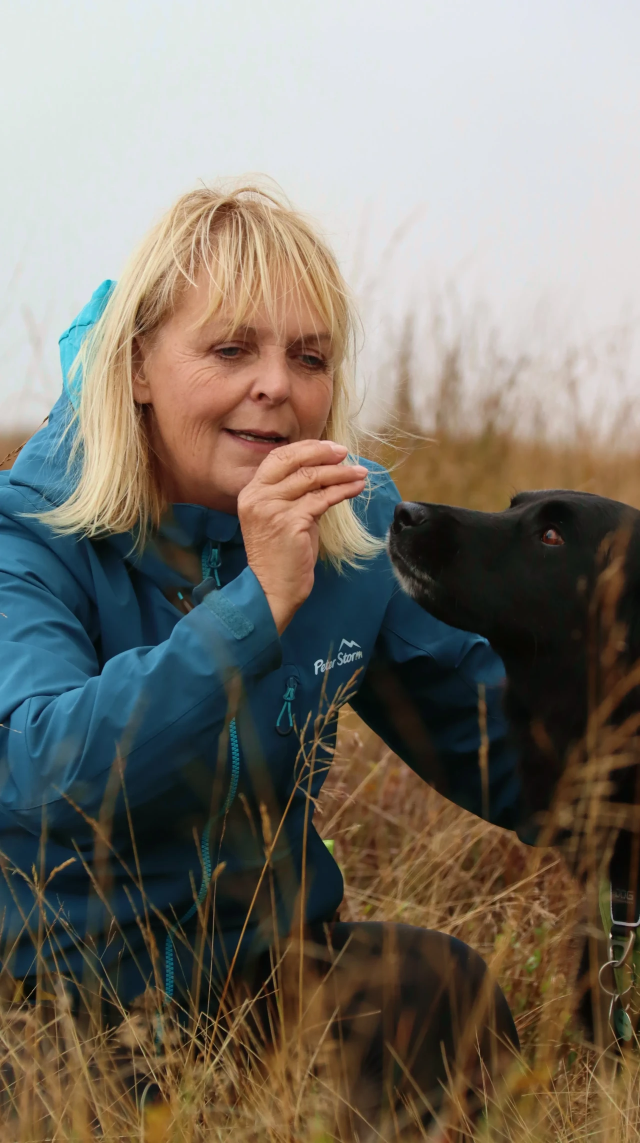 Victoria rewarding black dog with treat