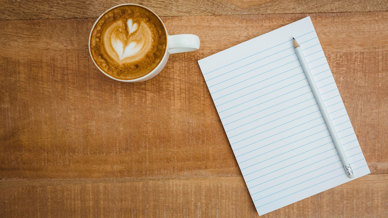 Kaffe, anteckningsblock och frågor om vad som krävs för att hålla som chef – en visuell symbol för hållbart ledarskap, återhämtning och reflektion i chefsrollen.