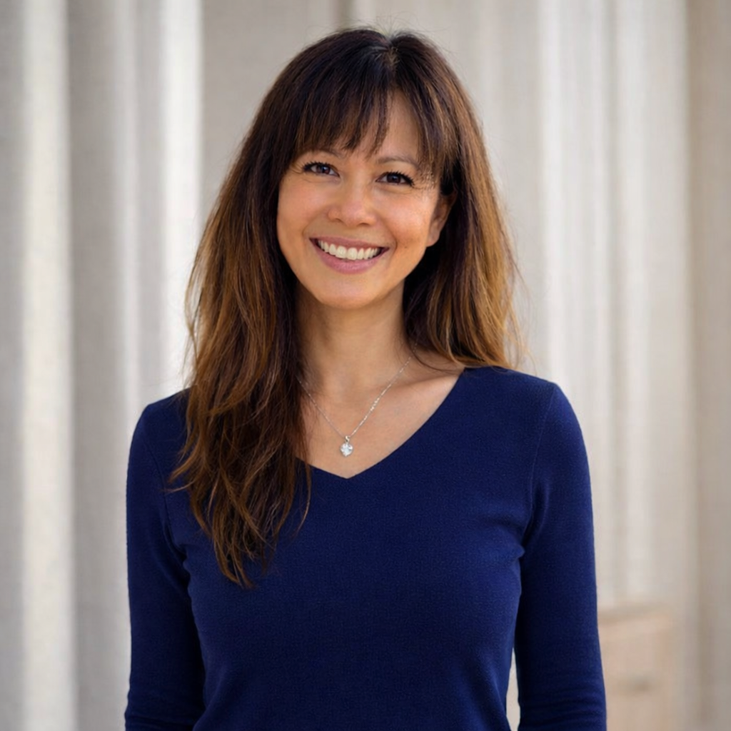 Author Jacqui Letran sitting at a desk at a book signing