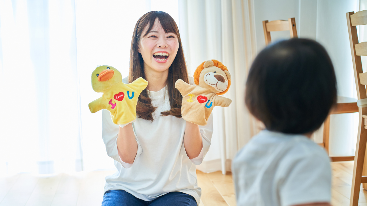 Play therapist and young client playing with puppets