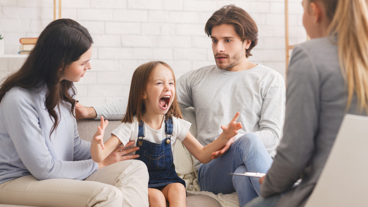 Shocked parents soothing their little daughter at a play therapy session