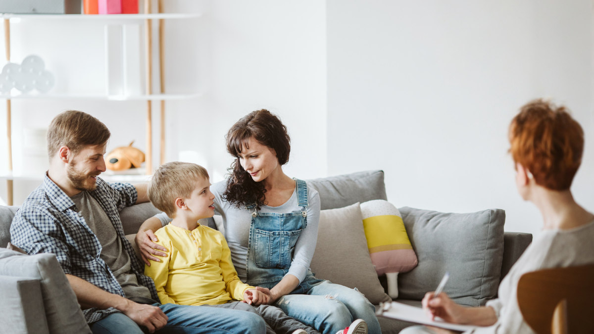 Parents with child sitting in a room with a play therapist