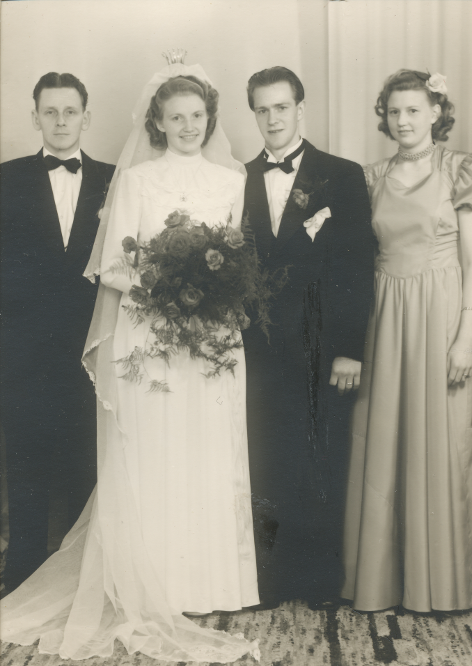 Svartvitt bröllopsfotografi med Mary och Erling tillsammans med brudtärna och marskalk.