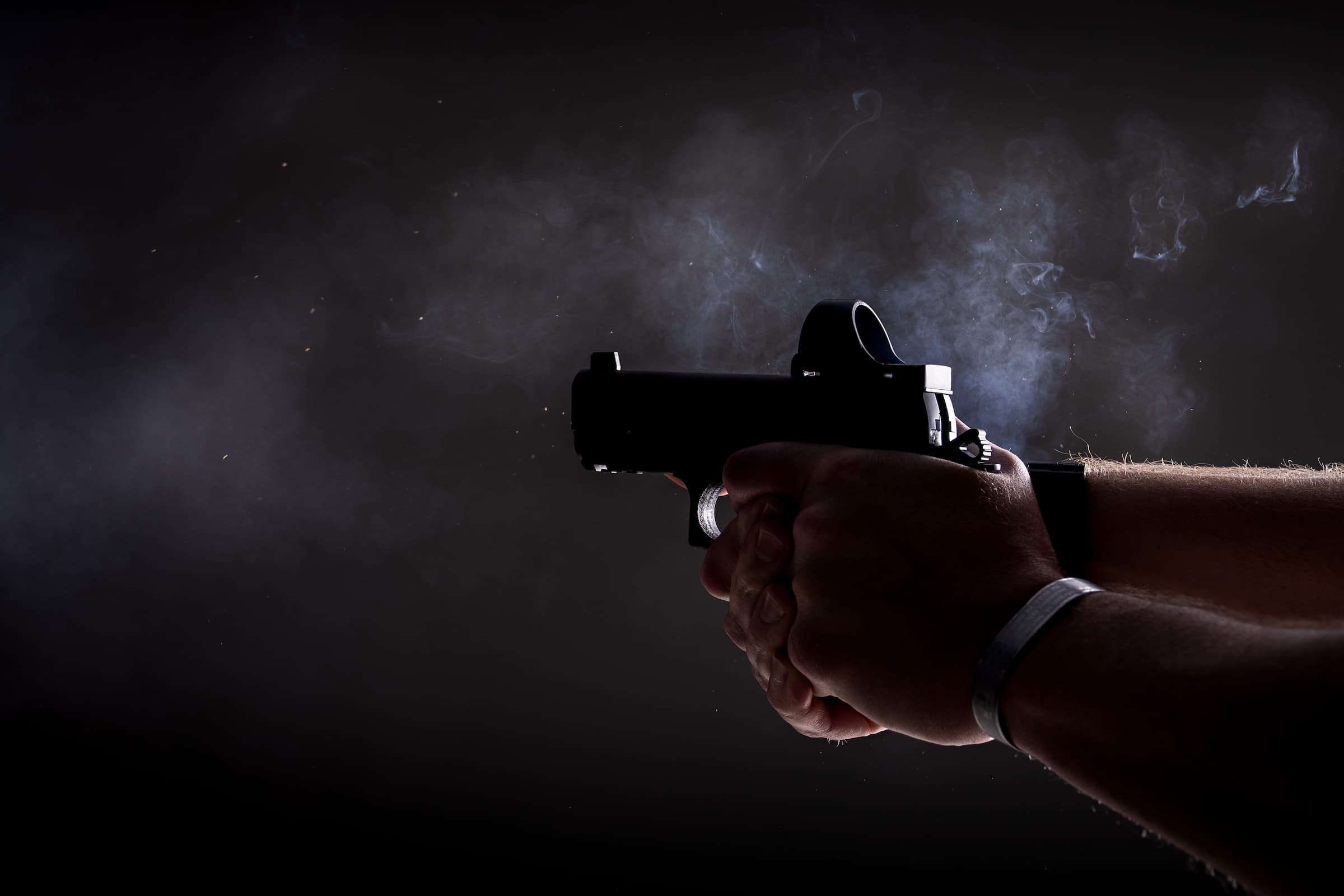 A Staccato 2011 fired at night, muzzle flash lighting the shooter’s hands