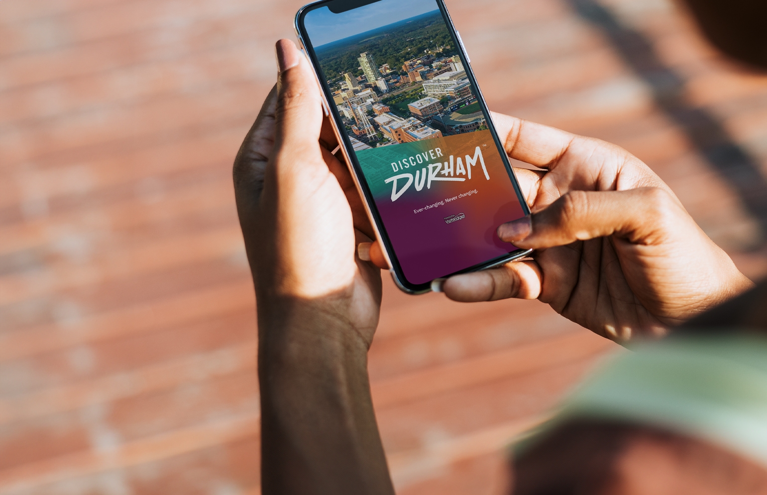 A woman scrolling the Discover Durham app on her phone