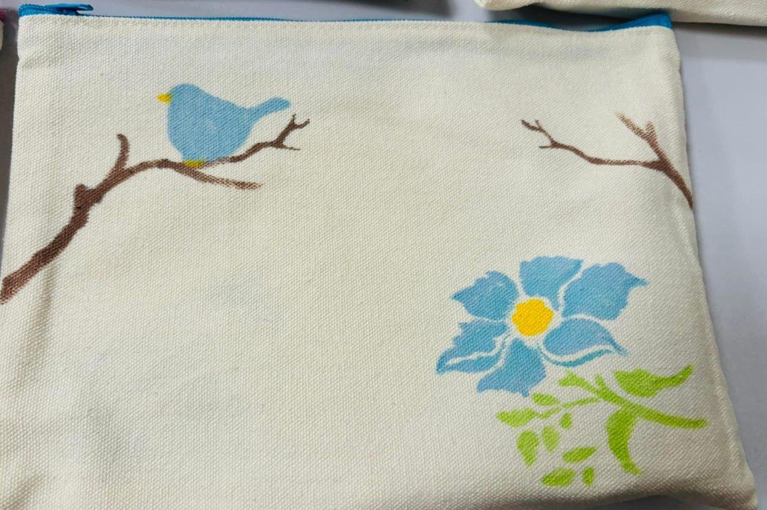 painted tote bag with bird, flower and branches on it