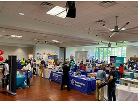 Large room with several tables set up with representatives with information on different kinds of wellness options