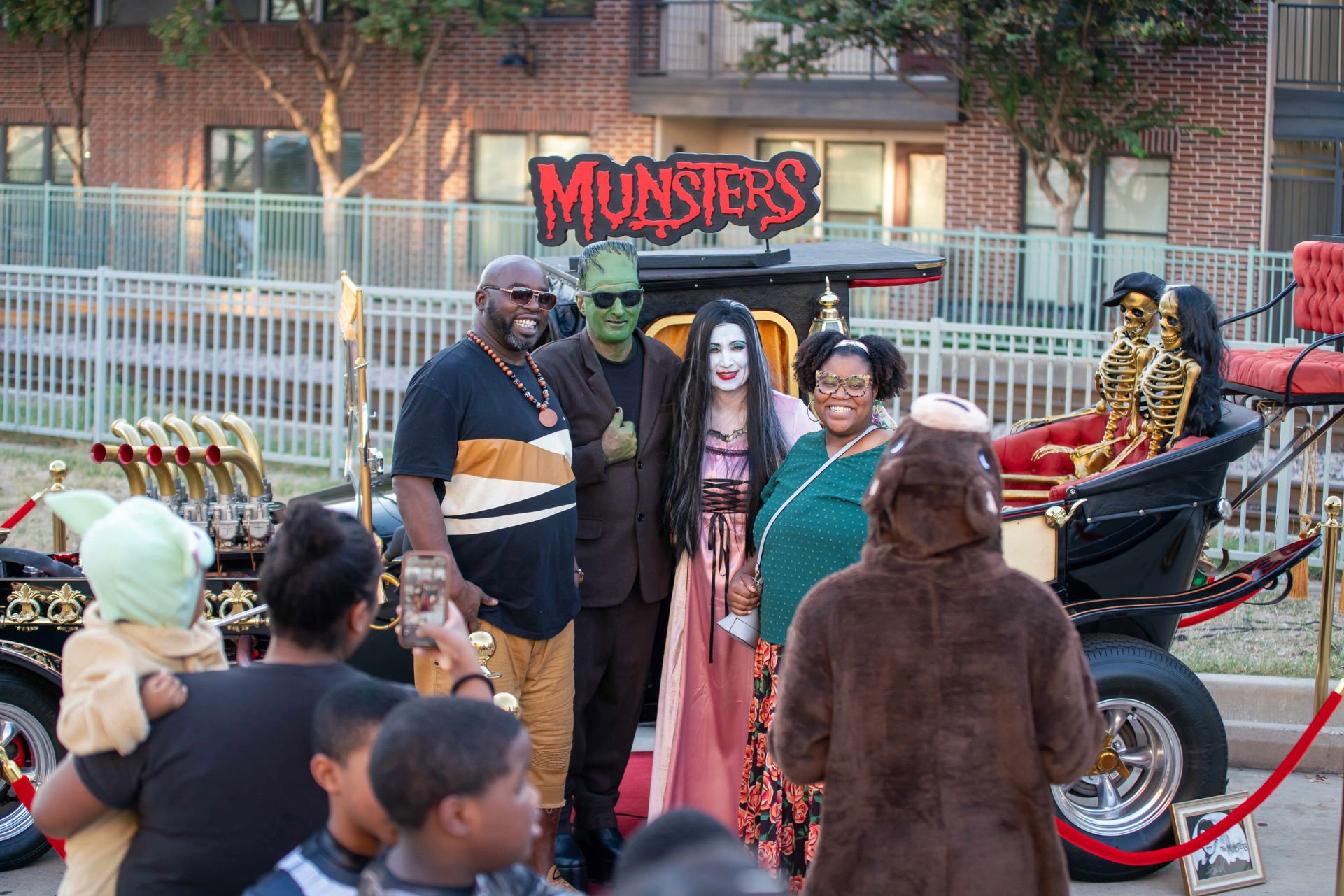 Photo opp with people posing in costumes and creepy skeletons in background