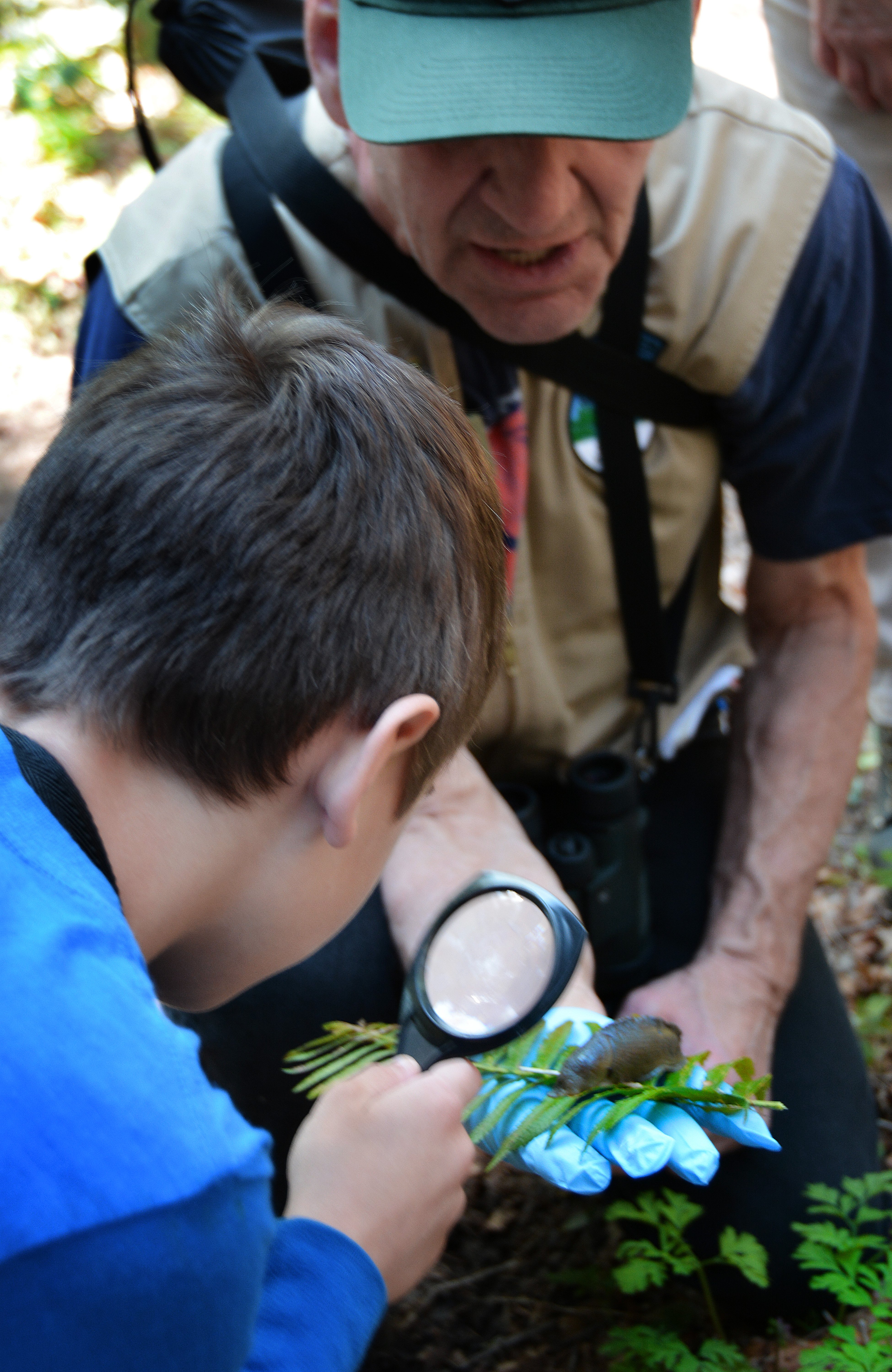 host showing kid slug stub Volunteer showing child a slug.