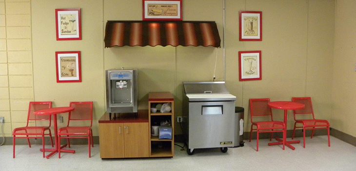 A cafe with a popcorn maker and ice cream area.